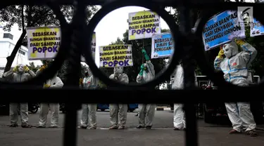 Sejumlah Aktivis Lingkungan menggunakan pakaian antiradiasi dan masker melakukan aksi protes pencemaran sungai Brantas di Kementerian Pekerjaan Umum dan Perumahan Rakyat, Jakarta, Jumat (19/1). (Liputan6.com/Johan Tallo)