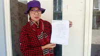 Darmiati Tansilong menunjukkan surat putusan MA. (Istimewa)