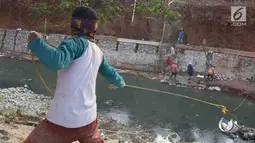 Pekerja membangun turap di bantaran Kali Cijantung, Jakarta Timur, Kamis (11/10). Pembangunan turap bertujuan mencegah longsor yang dapat membahayakan warga sekitar. (Liputan6.com/Immanuel Antonius)