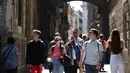 Turis berjalan di sepanjang Jalan Bisbe di Barcelona, ​​​​pada 11 Mei 2022. Pengunjung sekali lagi memadati jalan-jalan sempit di kawasan Gothic Barcelona yang sempit saat perjalanan global bangkit kembali dari pandemi COVID-19, menghidupkan kembali kekhawatiran atas pariwisata massal di kota pelabuhan Spanyol.
(LLUIS GEN / AFP)