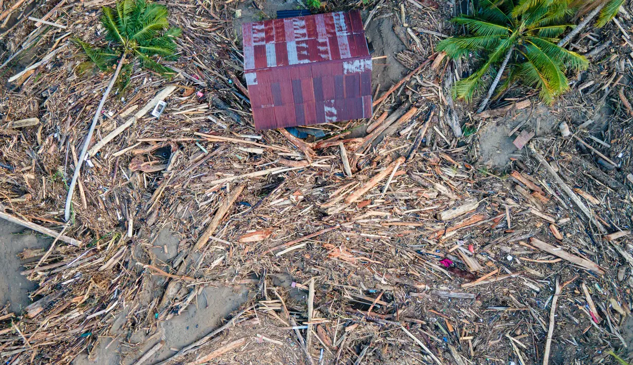 Banyak rumah hanyut, rusak berat hingga tertimbun lumpur yang menggunung. Tampak foto udara menunjukkan sampah kayu mengelilingi sebuah rumah di tengah kerusakan akibat banjir di Meureudu, Kabupaten Pidie Jaya, Provinsi Aceh, pada 30 November 2025. (CHAIDEER MAHYUDDIN/AFP)