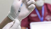 Petugas menyiapkan vaksin COVID-19 produksi Sinovac untuk disuntikkan kepada tenaga kesehatan saat kegiatan vaksinasi di RSCM di Jakarta, Senin (8/2/2021). Kementerian Kesehatan secara resmi memulai vaksinasi tenaga kesehatan di atas 60 tahun pada hari ini. (Liputan6.com/Faizal Fanani)