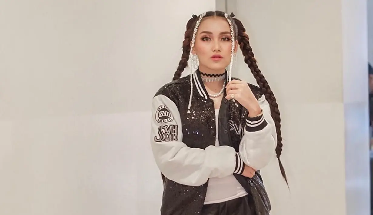 Tampil dengan gaya boyish pakai jaket hitam-putih, gaya rambut kepang dua Ayu Ting Ting membuat ia tampil bak idol Kpop. Banyak penggemar yang memuji penampilan ibu satu anak itu. (Liputan6.com/IG/@ayutingting92)