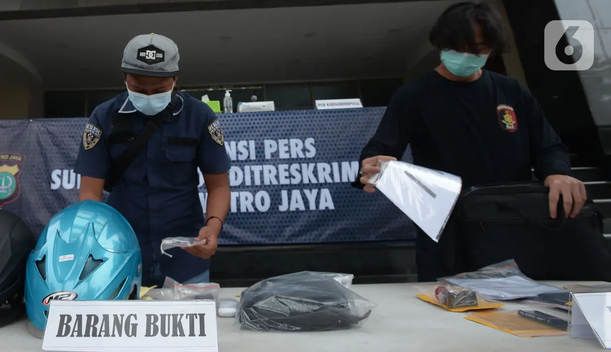 Petugas menata barang bukti dalam rilis tindak pidana pemalsuan surat hasil tes PCR dan swab antigen di Polda Metro Jaya, Selasa (13/7/2021). Polda Metro Jaya menangkap dua tersangka berinsial NI dan NFA itu ditangkap di Tangerang, Banten pada Sabtu, 10 Juli 2021. (merdeka.com/Imam Buhori)