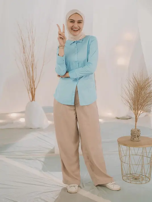 Zee Zee Shahab juga tampil memadukan warna biru dalam outfitnya. Ia mengenakan kemeja lengan panjang berwarna biru muda polos, dipadunya mengenakan celana panjang cokelat yang serasi dengan hijabnya. [Foto: Instagram/raffinagita1717]