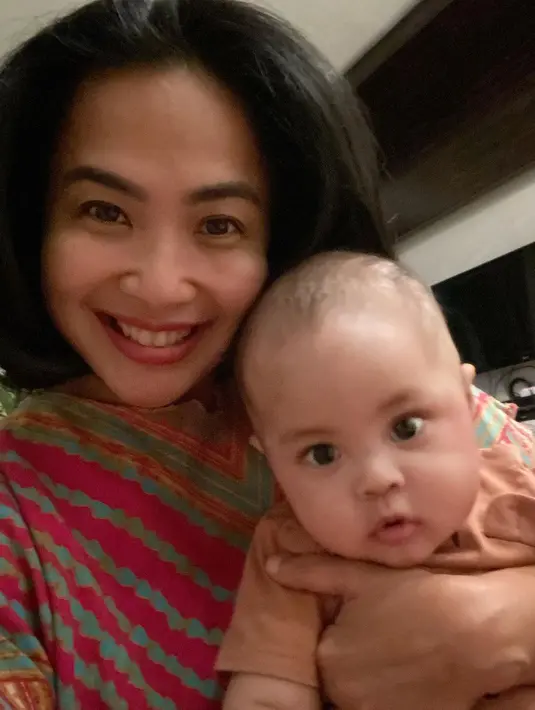Siapa yang sangka jika pembawa acara yang selalu tampil cantik awet muda ini juga sudah menjadi seorang nenek? Tampil dengan menggendong sang cucu yang lucu, Feni Rose terlihat bahagia. Foto: Instagram.