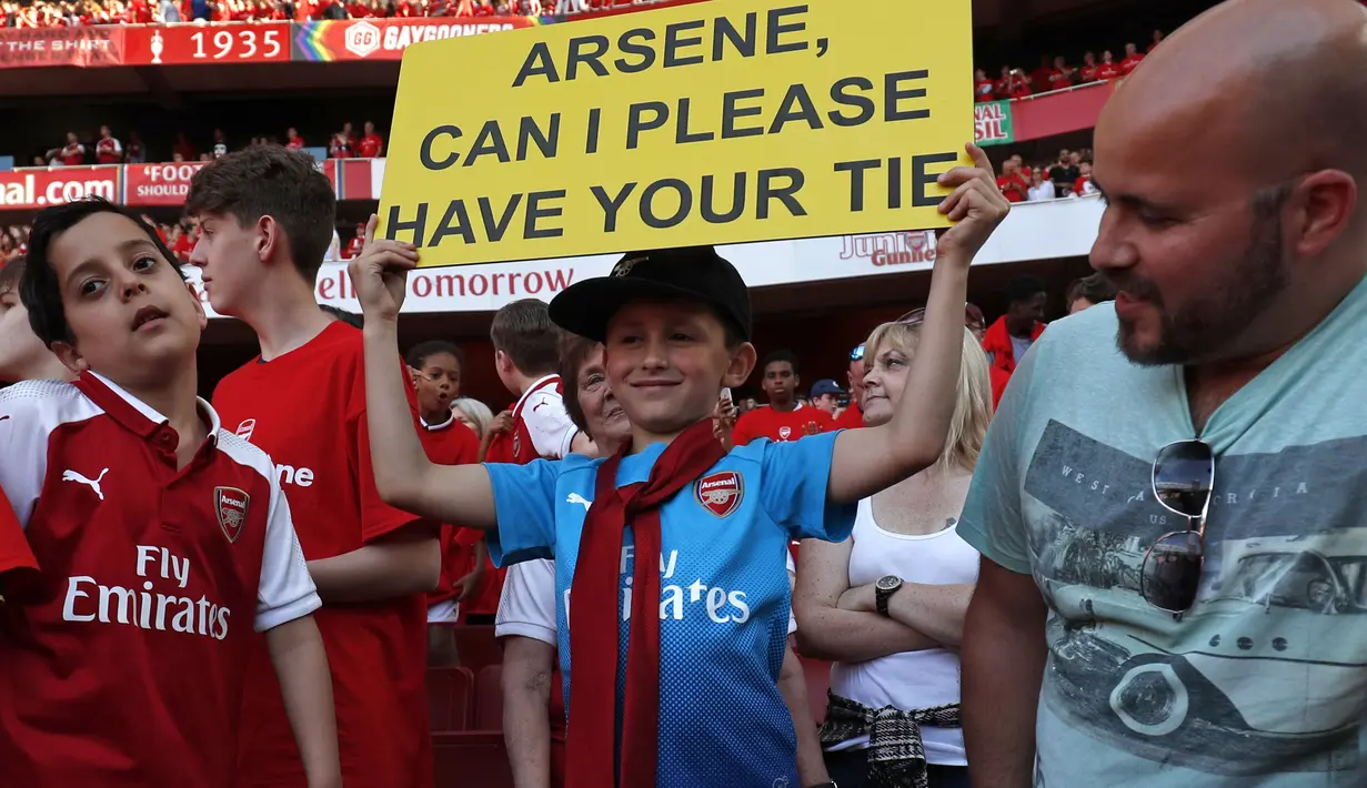 Fans cilik bahagia menerima dasi dari pelatih Arsene Wegner di Emirates Stadium, London, (6/5/2018). Arsene Wegner mengumumkan mundur sebagai pelatih setelah 22 tahun bersama Arsenal. (AFP/Adrian Dennis)