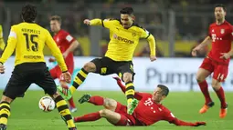 Pemain Bayern Munchen, Robert Lewandowski terjatuh saat berduel dengan pemain Dortmund Mats Hummels (kiri) dan Ilkay Gundogan pada lanjutan Bundesliga 2015-2016 di Stadion Signal Iduna Park ,Dortmund, Minggu (5/3/2016) dini hari WIB. (EPA/Ina Fassbender)