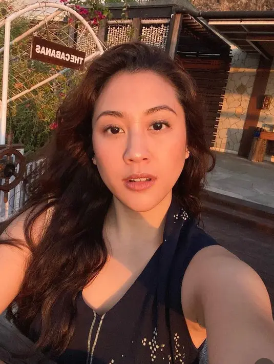 Dengan rambut panjang bergelombang, Sherina memerlihatkan wajah natural tanpa makeup berlebih. Ia hanya tampil dengan lipstik mattenya. Cahaya senja di wajahnya pun membuat ia begitu memesona. [@sherinamunaf]