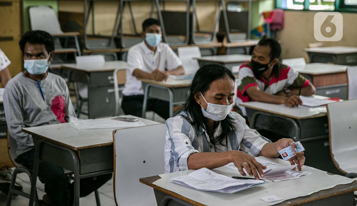 Warga menunggu untuk mengambil Bantuan Sosial Tunai (BST) di SMAN 111, Jakarta, Selasa (19/1/2021). Pemprov DKI Jakarta menyalurkan BST sebesar Rp 300 ribu kepada 1.055.216 KK mulai Januari hingga April 2021. (Liputan6.com/Faizal Fanani)