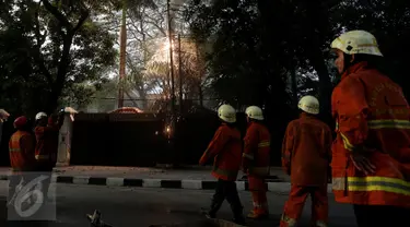 Petugas kebakaran berusaha memantau percikan api yang keluar dari kabel listrik setelah hujan deras mengguyur sore ini, di Jalan Imam Bonjol No 2, Jakarta, Selasa (28/3). Percikan tersebut di duga dari konsleting listrik. (Liputan6.com/JohanTallo)