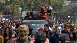 Ratusan orang mengenakan kostum menyerupai zombie berpartisipasi dalam perayaan satu dekade Zombie Walk di Santiago, Chile, 13 Oktober 2018. Zombie Walk digelar dua minggu sebelum perayaan Halloween pada 31 Oktober mendatang. (AP/Esteban Felix)