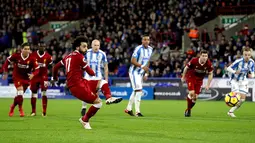 Pemain Liverpool, Mohamed Salah mencetak gol ke gawang Huddersfield Town lewat titik putih pada pertandingan pekan ke-25 Premier League di John Smith's Stadium, Selasa (30/1). Liverpool menghempaskan Huddersfield Town 3-0. (Martin Rickett/PA via AP)