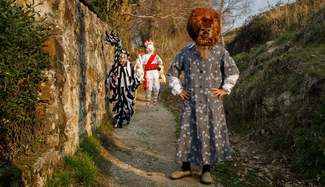 Peserta berpose mengenakan kostum sebelum karnaval La Vijanera di Silio, Spanyol (8/1). Karnaval tersebut merupakan pesta kostum yang digelar setiap tahun pada minggu pertama setelah tahun baru. (AFP/Cesar Manso)