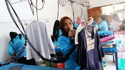 Pekerja menyetrika pakaian yang menggunakan energi dari gas alam (CNG) PGN di Bogor Laundry, Bogor, Kamis (28/9). Bisnis laundry tersebut dapat meraih keuntungan perhari hingga 10 juta. (Liputan6.com/Angga Yuniar)