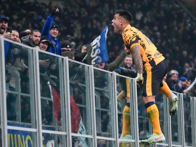 Pemain Inter Milan, Lautaro Martinez, melakukan selebrasi memanjat pagar setelah mencetak gol ke gawang Genoa dalam laga Serie A 2024/2025 giornata 26 yang dihelat di Giuseppe Meazza, Minggu (23/2/2025) dini hari WIB. (AP Photo/Luca Bruno)