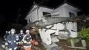 Petugas pemadam kebakaran memeriksa sebuah rumah yang runtuh setelah gempa bumi di kota Mashiki, Prefektur Kumamoto, Jepang selatan , Jumat (15/4). Gempa berkekuatan 6,4 SR itu menewaskan sembilan orang dan 760 lainnya terluka. (REUTERS/Kyodo)