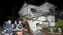 Petugas pemadam kebakaran memeriksa sebuah rumah yang runtuh setelah gempa bumi di kota Mashiki, Prefektur Kumamoto, Jepang selatan , Jumat (15/4). Gempa berkekuatan 6,4 SR itu menewaskan sembilan orang dan 760 lainnya terluka. (REUTERS/Kyodo)