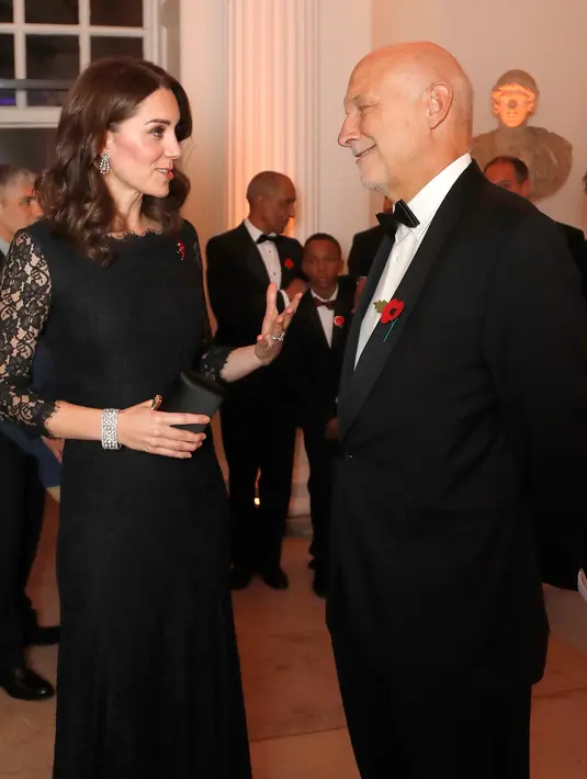 Kate Middleton berbincang dengan CEO Anna Freud, Peter Fonagy pada sebuah acara amal di Kensington Palace, London, Selasa (7/11). Kate juga tampak membawa tas kecil hitam yang digunakan untuk menutup bagian perutnya. (AP/Frank Augstein, pool)