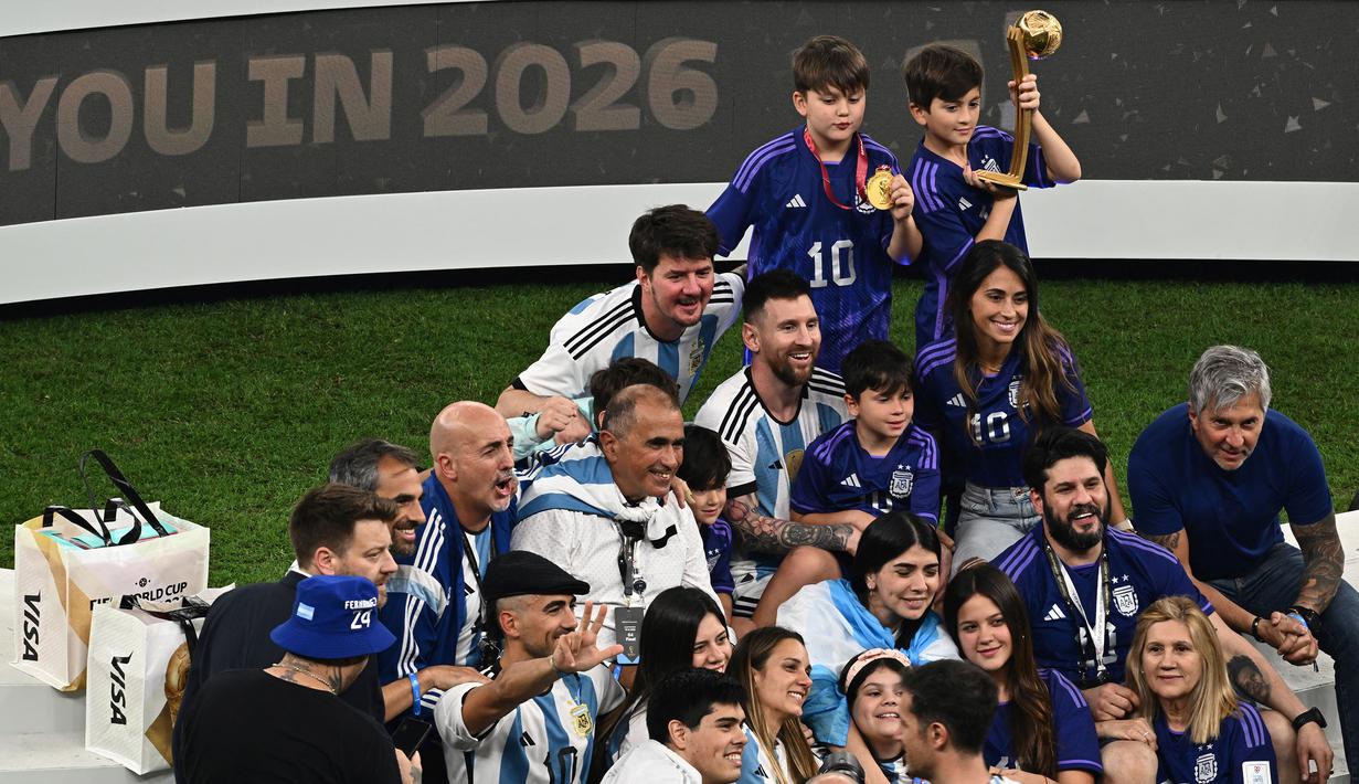Pemain Argentina, Lionel Messi merayakan kemenangan timnya di Piala Dunia 2022 bersama keluarganya setelah mengalahkan Prancis pada laga final yang berlangsung di Lusail Stadium, Qatar, Minggu (18/12/2022). Albiceleste menang 4-2 atas Prancis di babak penalti. (AFP/Jewel Samad)