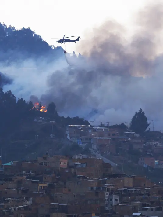 Helikopter dikerahkan untuk memadamkan api di daerah perbukitan dekat Bogota , Kolombia, 2 Februari 2016. Belum diketahui penyebab kebakaran ini.  (REUTERS / John Vizcaino)