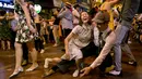 Pria dan wanita menari di depan kuil Phra Pathom Chedi di provinsi Nakhon Pathom, Thailand (25/2). Lebih dari 300 peserta termasuk penari asing bernari menghebohkan sebuah jalan sekitar satu jam. (AFP Photo/Thai News Pix/Krit Promsakla Na Sakolnakorn)