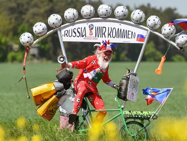 Perancang sepeda asal Jerman, Dieter Senft atau Didi the Devil saat mengendarai sepeda unik buatannya di Briesen, Jerman Timur, Senin (7/5). Aksi itu dia lakukan untuk mempromosikan Piala Dunia 2018. (Patrick Pleu/dpa/AFP)