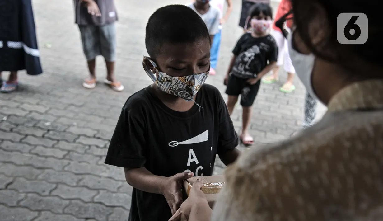 Seorang anak menerima donasi ponsel yang diberikan oleh Komunitas #WartawanLintasMedia saat acara #PonselPintarUntukPelajar di Jakarta, Minggu (9/8/2020). (merdeka.com/Iqbal S. Nugroho)