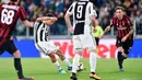 Striker Juventus Paulo Dybala melakukan tendangan yang akhirnya berbuah gol saat melawan AC Milan pada pertandingan Serie A Italia di Stadion Allianz di Turin (31/3). Dybala berhasil menyumbang satu gol untuk Juventus. (Alessandro Di Marco/ANSA via AP)
