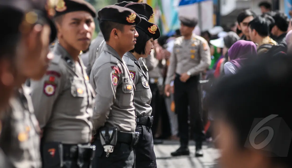Petugas kepolisian berbaris menjaga jalan yang dilalui Para kepala Negara dan delegasi dari Asia dan Afrika mengikuti 'Historical Walk' dalam rangkaian Peringatan KAA ke-60, di Jalan Asia Afrika, Bandung, Jumat (24/4/2015). (Liputan6.com/Faizal Fanani)