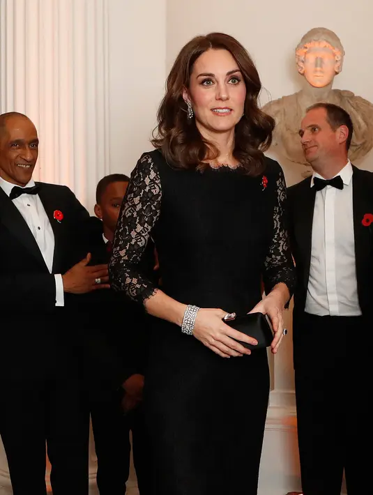 Kate Middleton menghadiri sebuah acara amal di Kensington Palace, London, Selasa (7/11). Sang Duchess of Cambridge itu terlihat elegan dalam balutan gaun lace hitam yang menyamarkan perut buncitnya di kehamilan ketiga. (AP/Frank Augstein, pool)