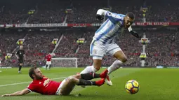 Pemain Manchester United, Juan Mata menghalau bola dari kaki pemain Huddersfield Town, Collin Quaner pada laga Premier League di Old Trafford, Manchester, (3/2/2018). MU menang 2-0. (Martin Rickett/PA via AP)