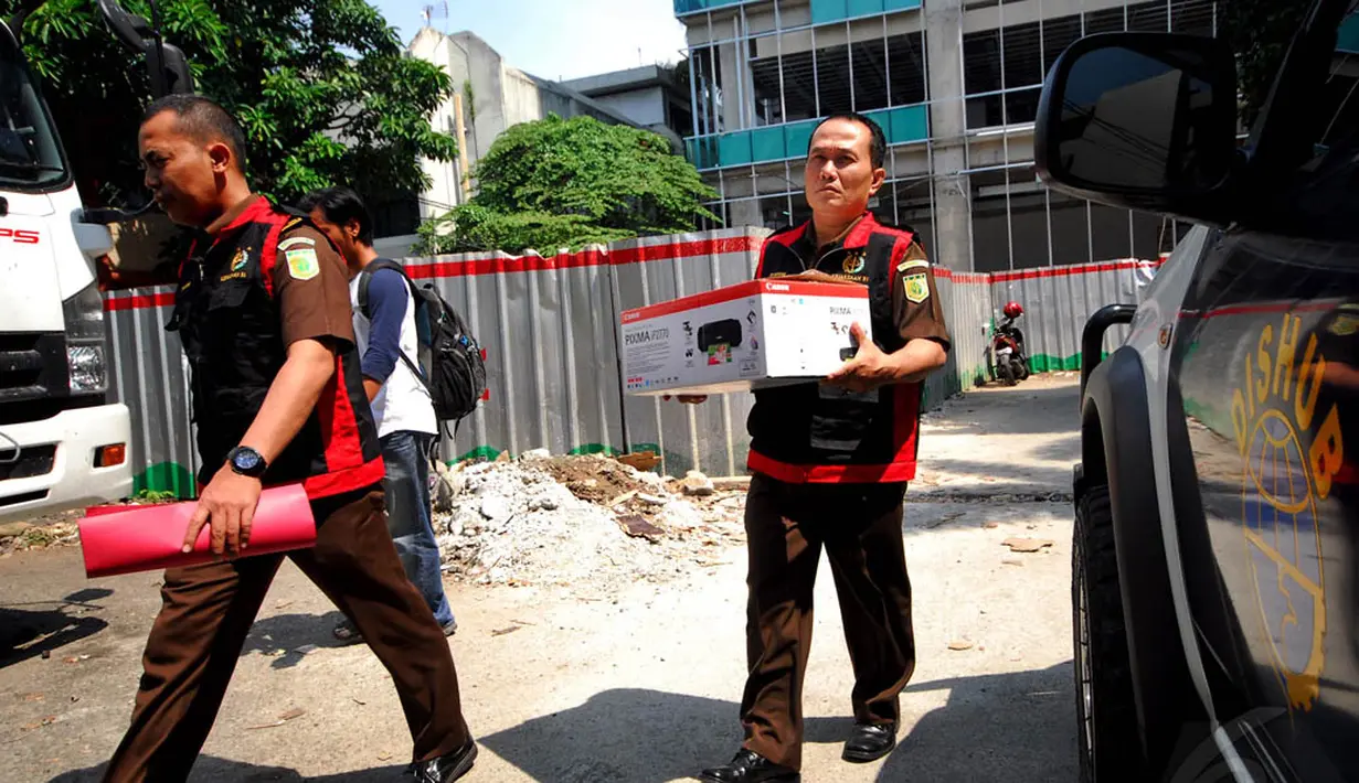 Petugas membawa barang bukti dokumen yang berhasil dikumpulkan dari kantor Dinas Perhubungan dalam sebuah kardus, Jakarta, (22/9/14). (Liputan6.com/Johan Tallo)