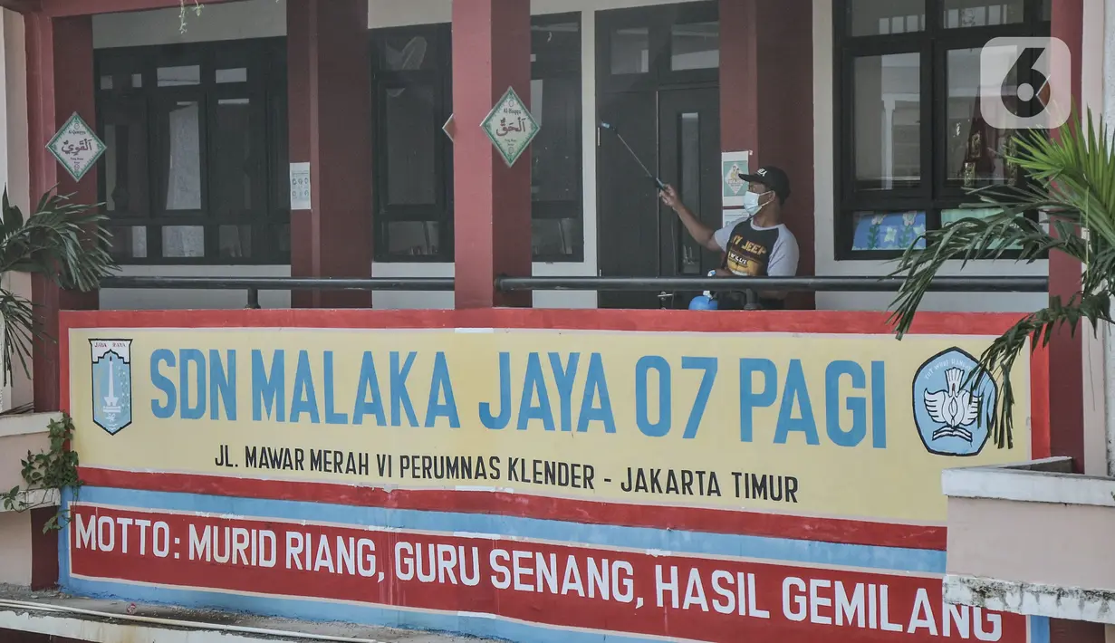 Petugas menyemprotkan disinfektan pada lorong kelas di SD Negeri Malaka Jaya 07 Pagi, Jakarta, Kamis (26/8/2021). Pemprov DKI berencana membuka kembali sekolah untuk pembelajaran tatap muka terbatas pada Senin (30/8) setelah status PPKM turun ke level 3. (merdeka.com/Iqbal S Nugroho)
