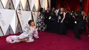 Penyanyi Andra Day berpose untuk fotografer sambil rebahan di karpet merah di penghargaan Piala Oscars 2018 di Dolby Theatre, Los Angeles, Minggu (4/3). Andra Day tampil glamor dalam balutan gaun off-shoulder bermotif floral. (Jordan Strauss/Invision/AP)