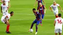 Striker Barcelona, Ansu Fati, berusaha melewati pemain Sevilla pada laga Liga Spanyol di Stadion Camp Nou, Minggu (4/10/2020). Kedua tim bermain imbang 1-1. (AP Photo/Joan Monfort)