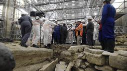 Menteri Kebudayaan Prancis Roselyne Bachelot (tengah kiri) mengunjungi situs penelitian arkeologi Katedral Notre Dame setelah penemuan sarkofagus timah abad ke-14, di Paris (15/3/2022). (AFP/Julien De Rosa)