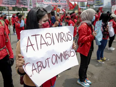 Massa buruh membawa poster saat menggelar unjuk rasa di depan Kompleks Gedung DPR/MPR, Jakarta, Selasa (17/11/2020). Buruh kembali menggelar aksi lanjutan menuntut pemerintah dan DPR untuk mencabut Omnibus Law Undang-Undang Cipta Kerja. (Liputan6.com/Faizal Fanani)