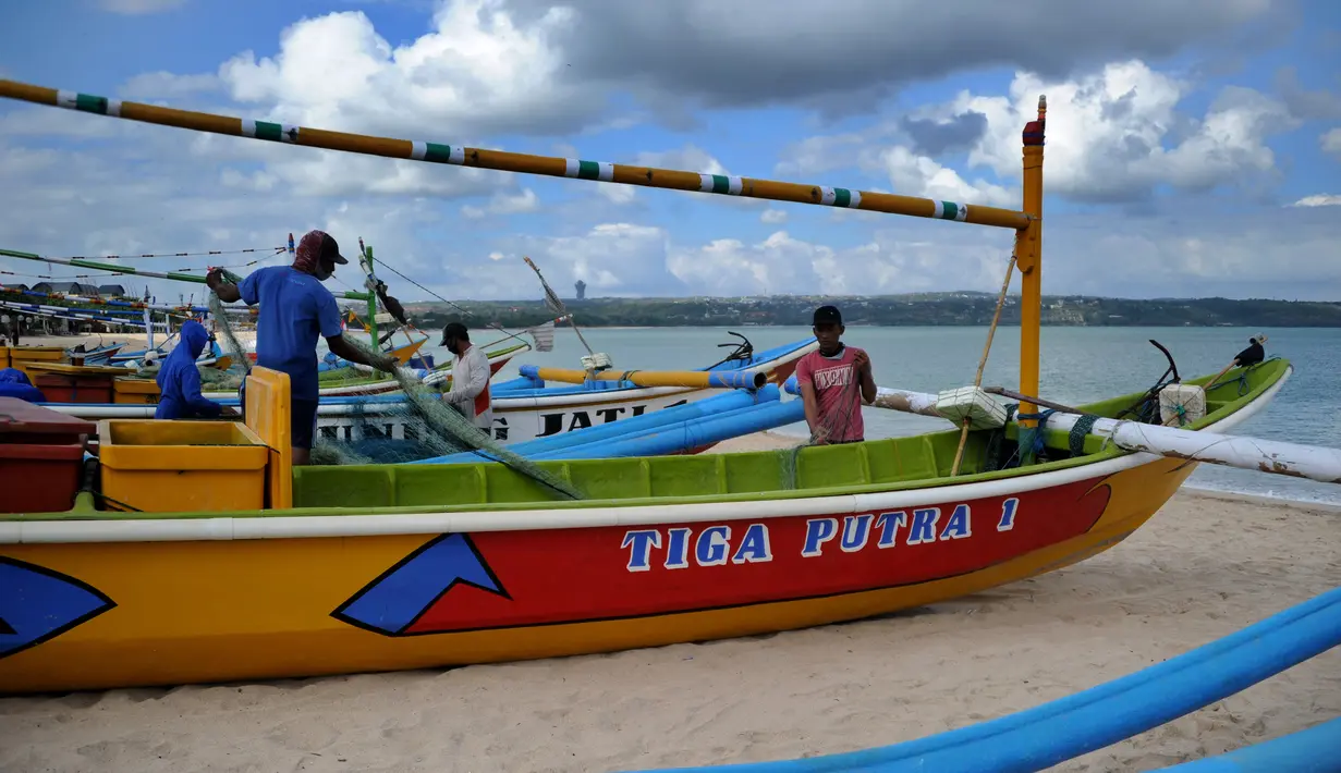 Nelayan menyiapkan jaring mereka sebelum berangkat ke laut setelah matahari terbenam saat Pemberlakuan Pembatasan Kegiatan Masyarakat (PPKM) Level 3 di Kedonganan, Kuta, Badung, Bali, Jumat (23/7/2021). PPKM Level 3 berlaku di seluruh wilayah kabupaten/kota di Bali. (SONY TUMBELAKA/AFP)