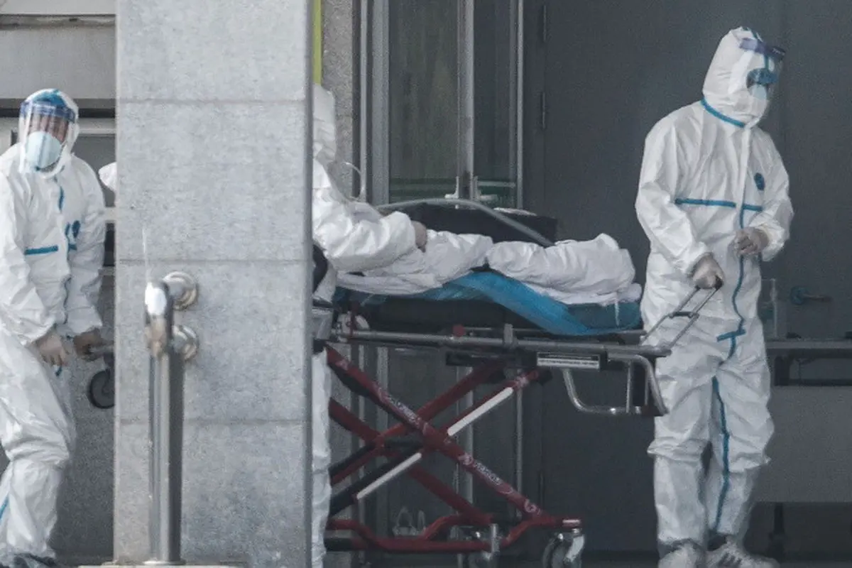 Staf medis memindahkan seorang pasien dari ambulans ke rumah sakit Jinyintan, tempat pasien-pasien terinfeksi virus corona dirawat di Wuhan, provinsi Hubei, China pada Senin 20 Januari 2020.