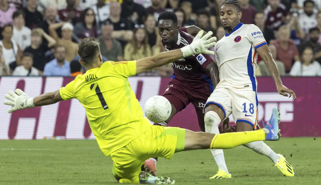 Gelandang Chelsea Christopher Nkunku berebut bola dengan kiper Servette Joel Mall (kiri) dan bek Servette Bradley Mazikou (tengah) pada leg kedua play-off UEFA Conference League 2024/2025 di Stadion de Gevene, Jumat (30/8/2024) dini hari WIB. (Salvatore Di Nolfi/Keystone via AP)