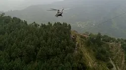 Sebuah helikopter militer menyelamatkan seorang anak, sementara sisanya diselamatkan dengan zip line atau flying fox. (AFP)