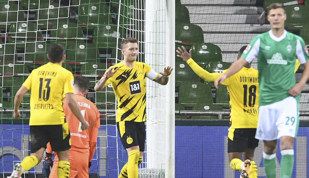 Striker Borussia Dortmund, Marco Reus (tengah) melakukan selebrasi usai mencetak gol kedua timnya ke gawang Werder Bremen dalam laga lanjutan Bundesliga Liga Jerman 2020/21 pekan ke-12 di Weserstadion, Bremen, Selasa (15/12/2020). Dortmund menang 2-1 atas Bremen. (AP/Carmen Jaspersen/Pool).