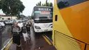 Peserta aksi damai 2 Desember di samping kendaraan yang terparkir di sepanjang Jalan Raya Pos, Jakarta, Jumat (2/12). Terbatasnya tempat parkir menyebabkan massa aksi memarkirkan kendaraan di tepi jalan. (Liputan6.com/Immanuel Antonius)