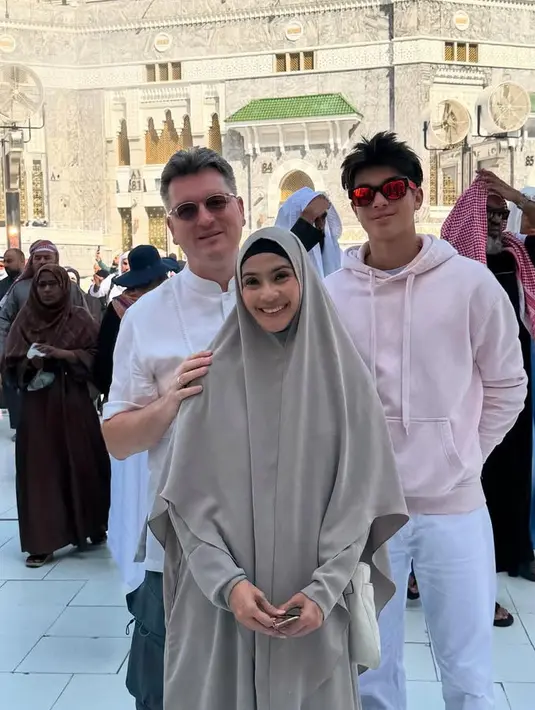 Maudy mengenakan abaya abu-abu senada dengan kerudung khimarnya dan ciput hitamnya. Eddy mengenakan hoodie pink dipadukan celana putih panjang. [@maudykoesnaedi]