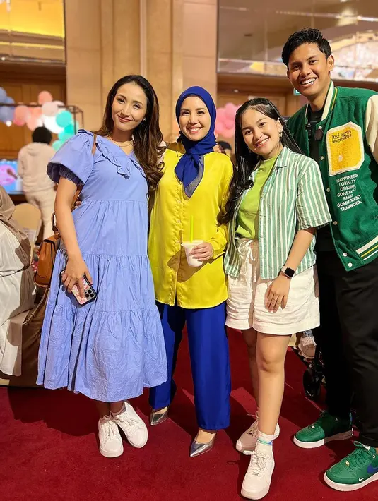 Di sampingnya ada Tya Ariestya yang mengenakan tunik warna kuning cerah dan dipadukan dengan loose pants dan hijab navy. [Instagram/tya_ariestya]