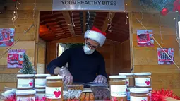 Seorang pedagang menata barang-barang di sebuah toko di kampung Natal di daerah Ashrafieh, Beirut, Lebanon, 6 Desember 2020. Sebuah kampung Natal dibuka pada Minggu (6/12) bagi para pedagang yang tokonya hancur akibat ledakan pelabuhan pada 4 Agustus lalu. (Xinhua/Bilal Jawich)