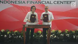 Menkeu Sri Mulyani (kiri) bersama Ketua Otoritas Jasa Keuangan (OJK) Wimboh Santoso menunjukkan dokumen saat seremonial pembangunan Kantor Pusat OJK di Jakarta, Selasa (2/4). Gedung Indonesia Financial Center diperuntukkan bagi OJK dan Kementerian Keuangan. (Liputan6.com/Angga Yuniar)