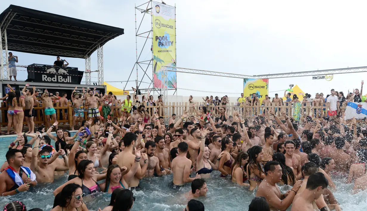 Sejumlah pengunjung berjoget menikmati musik di dalam kolam Festival Arenal Sound di Pantai Burriana, Spanyol (2/8). Festival musik ini berlangsung sampai 7 Agustus 2017. (AFP Photo/Jose Jordan)