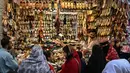 Suasana terlihat sibuk dan meriah dipadati warga yang akan membeli pakaian, sepatu, dan kebutuhan dekorasi Hari Raya Idul Fitri. Tampak dalam foto, Umat Muslim Pakistan berbelanja untuk perayaan Idul Fitri, selama minggu terakhir bulan suci Ramadan 1447 Hijriah, di Rawalpindi pada 14 Maret 2026. (Farooq NAEEM/AFP)